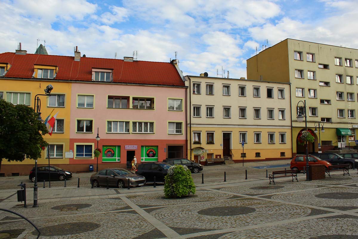 Hier sehen Sie mehrere Mehrparteienhäuser in einer Stadt mit einer Gewerbefläche im Untergeschoss. 