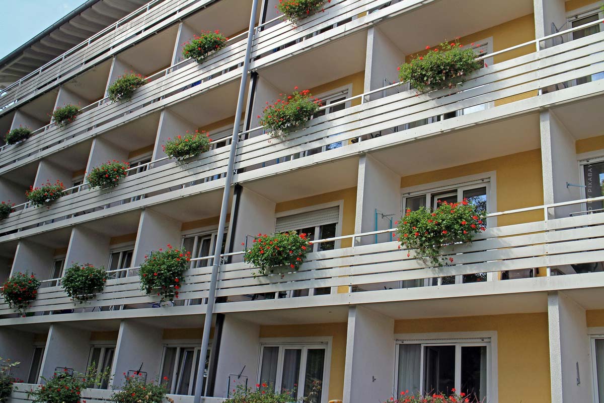 mehrfamilienhaus-kaufen-fassade-nrw-balkons-holzanbau-wertsteigerung-fenster-baujahr