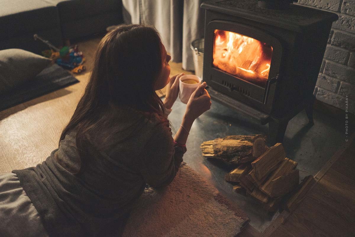 kamin-ofen-feuer-kalte-winterzeit-heissgetrank-kaffee-schokolade-holz-frau-warmen