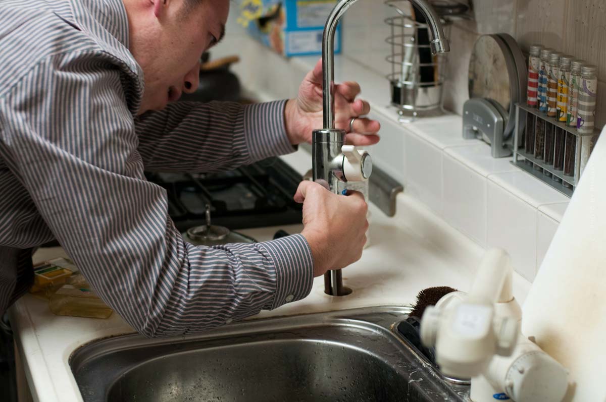 Handwerker beim Einbau einer Spüle in der Küche