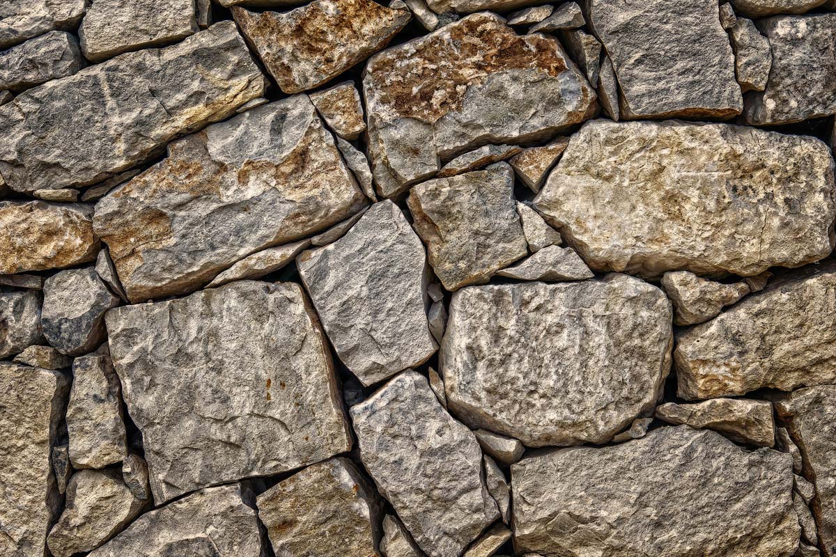 Eine Mauer aus unterschiedlich großen Steinen in den Farben beige und braun