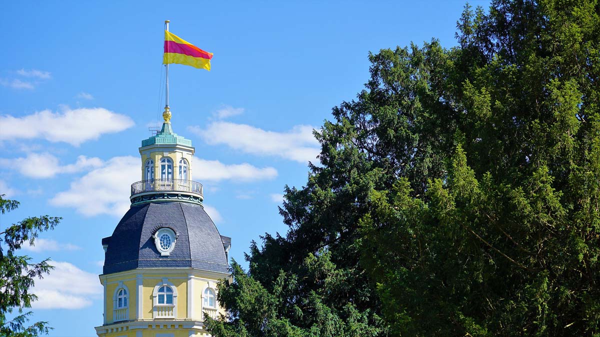 karlsruhe-schloss-schlossturm-fahne-wald-baum-himmel-schlosspark-haus-immobilie-architekt-bauen-investition-eigenkapital-markler-mehrfamilienhaus