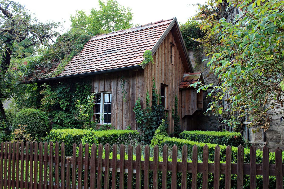 Ein Holzhaus auf einem Grundstück umgeben von grüner Natur