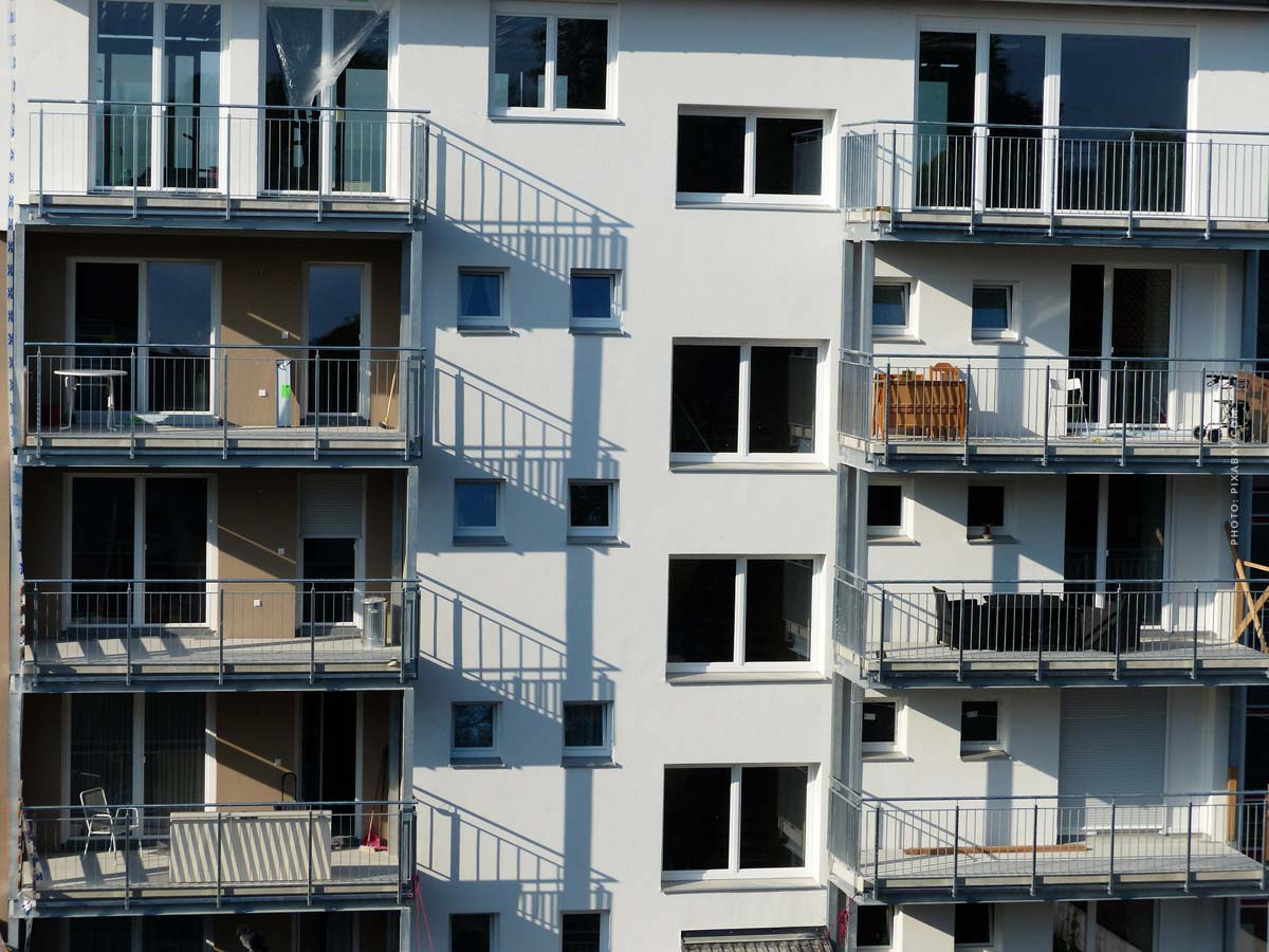 Hier sehen Sie ein typisches Mehrfamilienhaus mit mehreren Wohnungen und Balkonen. 