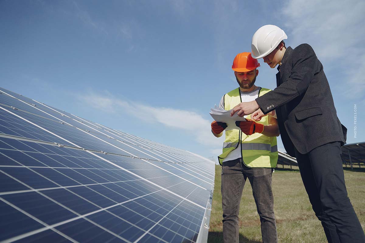 solaranlage-photovoltaikanlage-männer-prüfen-helme-bauarbeiter-haus-hausbesitzer-parkplatz