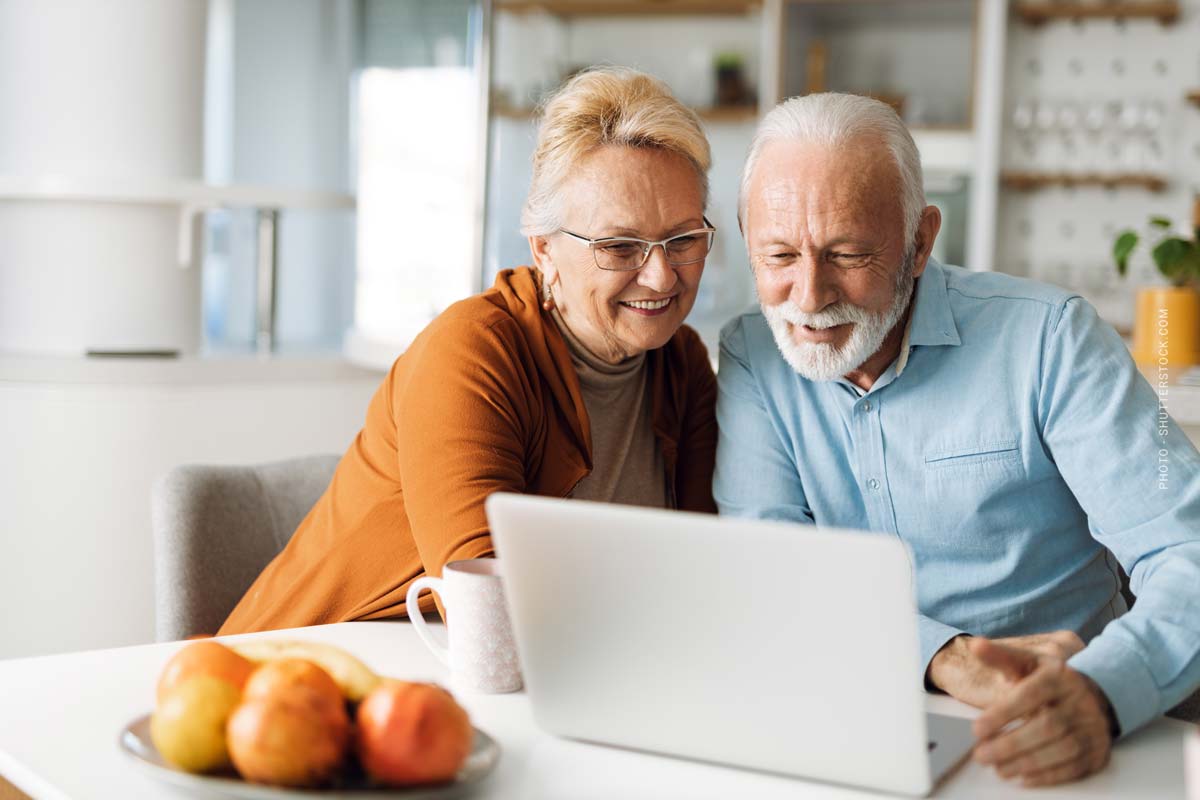 immobilie-teilverkauf-vorteile-nachteile-ablauf-vergleich-anbieter-mann-frau-rentner-laptop-lachen