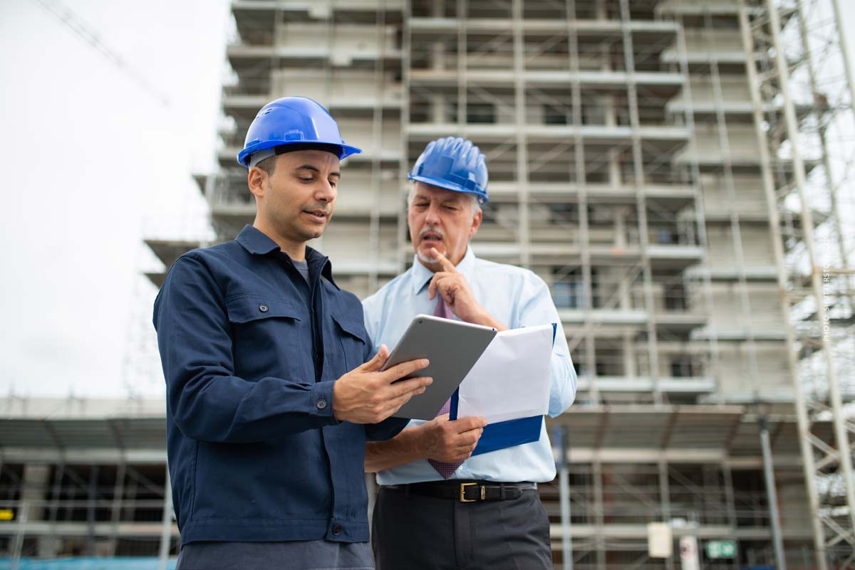 ki-immobilie-projektentwickler-vorarbeiter-baustelle-gewerbepark-besprechung-sprechen-entscheidung-geruest