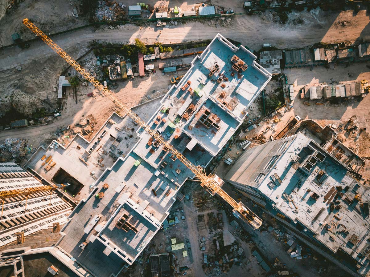 ki-bauindustrie-baustelle-baufahrzeug-kran-versetzt-sich-selbst-drohn-flug-von-oben